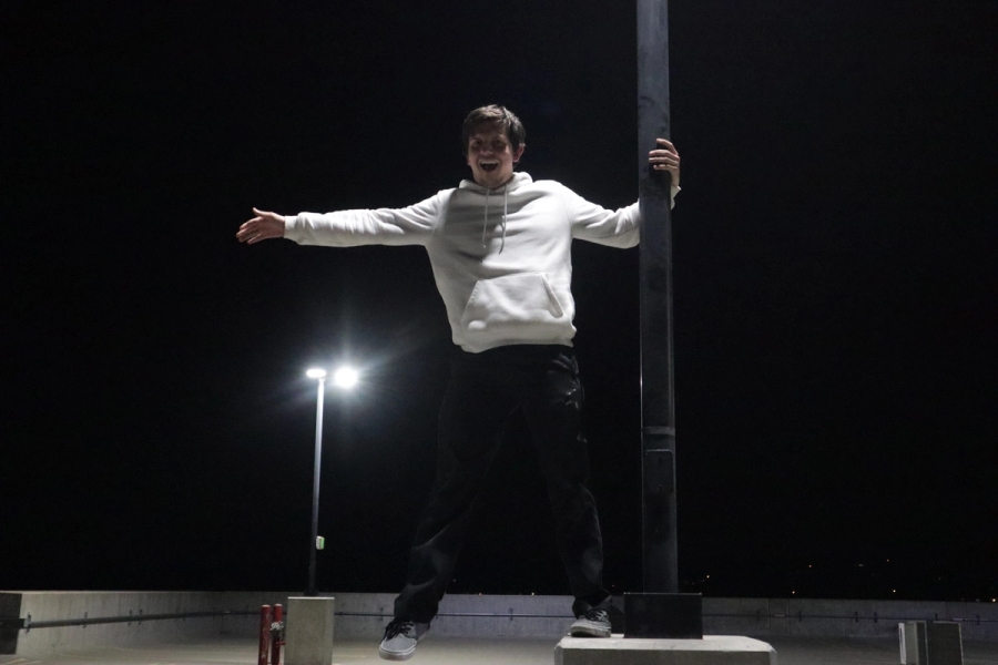 Boy with one leg on lamppost.