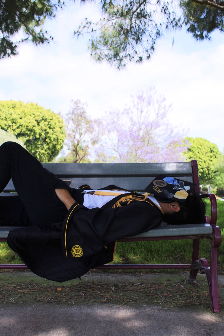 Man in grad fit laying on bench.