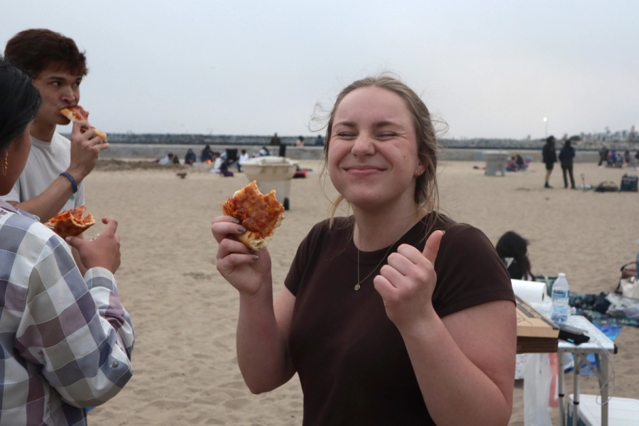 Girl with pizza smiling.