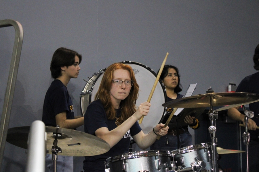 Girl playing drums with other percussionists.