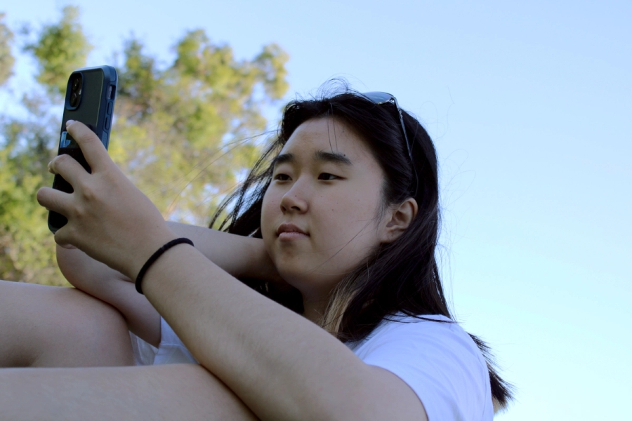 Asian girl looks at phone.