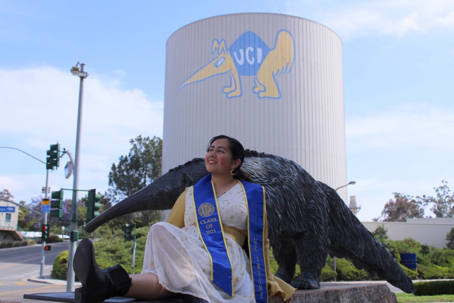 Girl sitting in front of anteater statue.