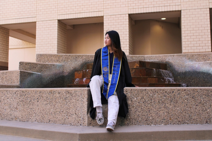Girl sitting in front of fountain.