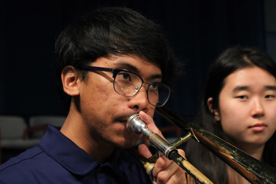 Boy practicing on the trombone.