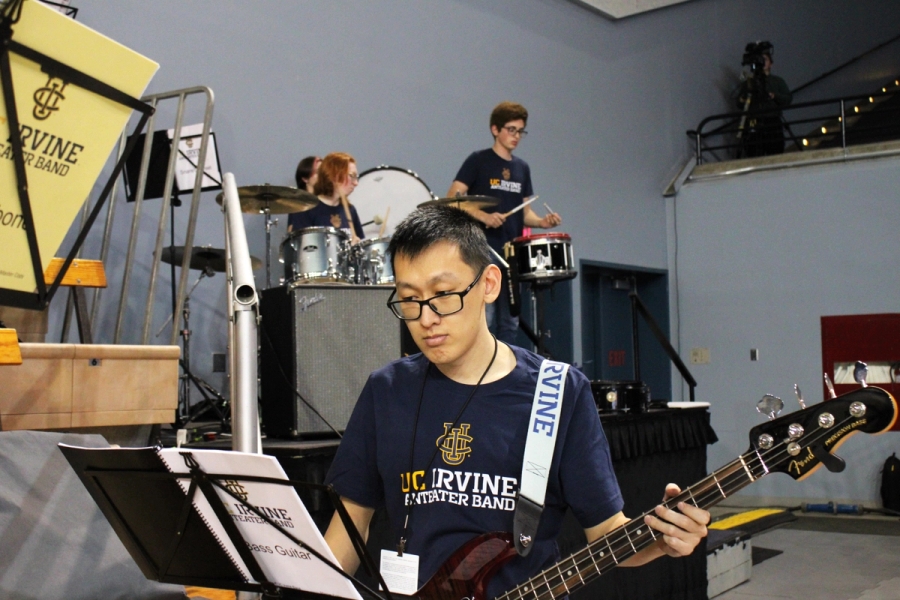 Man playing bass in front of percussion section.