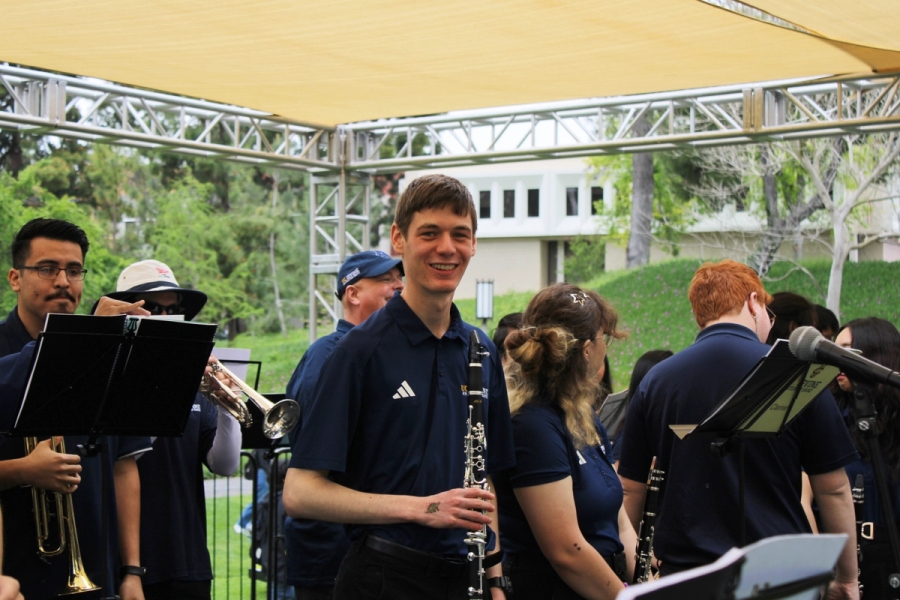Boy smiling while holding clarinet.