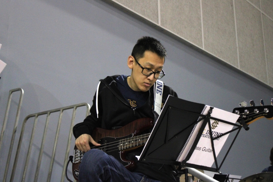 Man playing bass with one leg up.