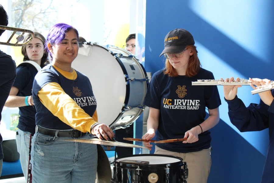 Girl holding cymbals and another playing snare.