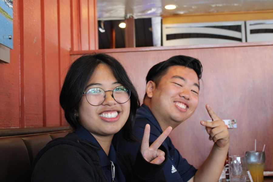 Boy and girl holding peace signs.