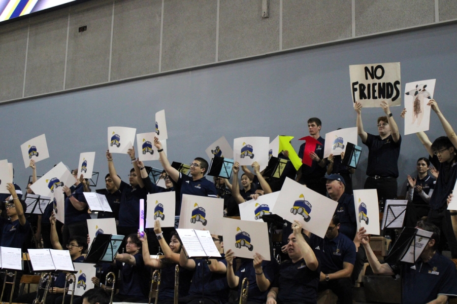 Band holding up ZotBot signs.