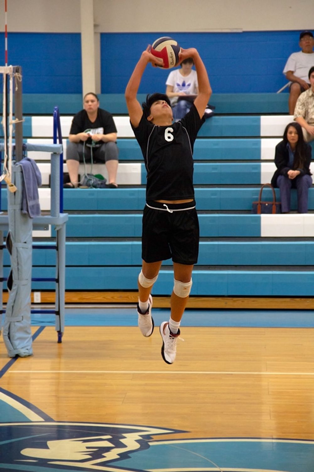 A volleyball player setting in the middle of a game.