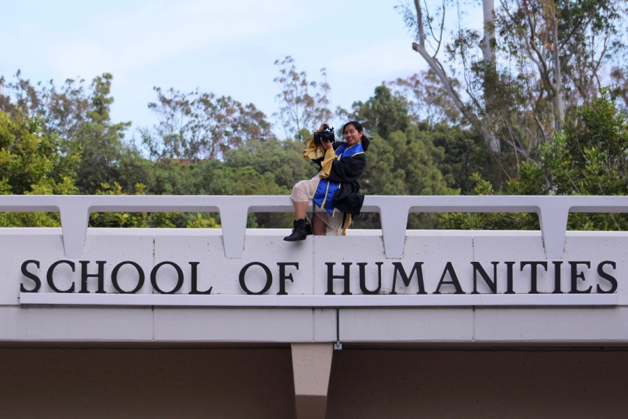 Girl holding a camera on school sign.
