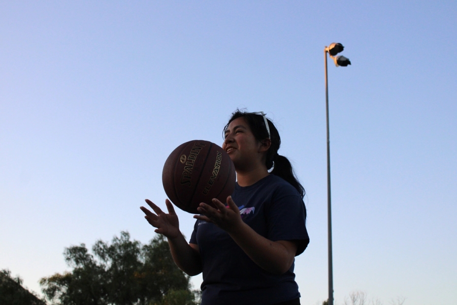 Girl throwing basketball up.