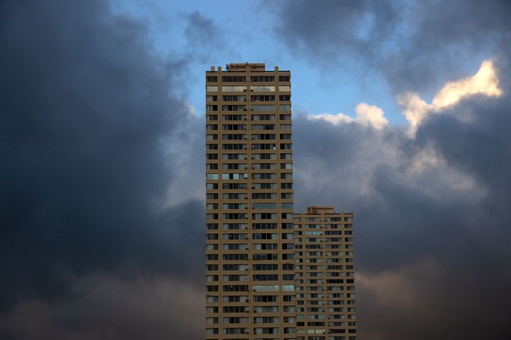 Two similar towers surrounded by clouds.