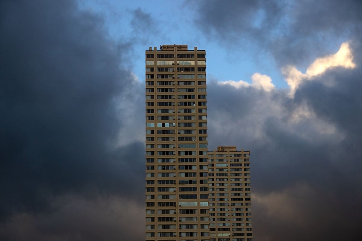 Two similar towers surrounded by clouds.