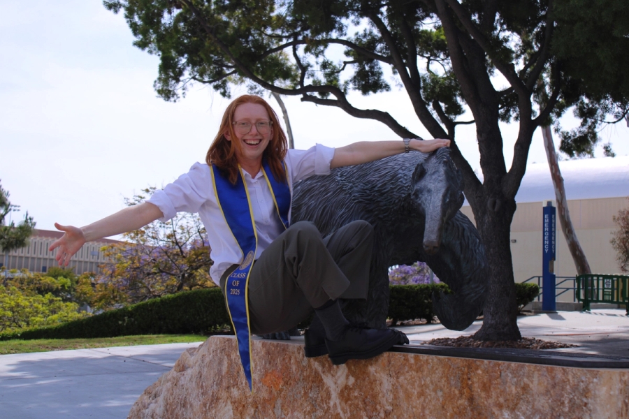 Girl hanging from anteater statue.