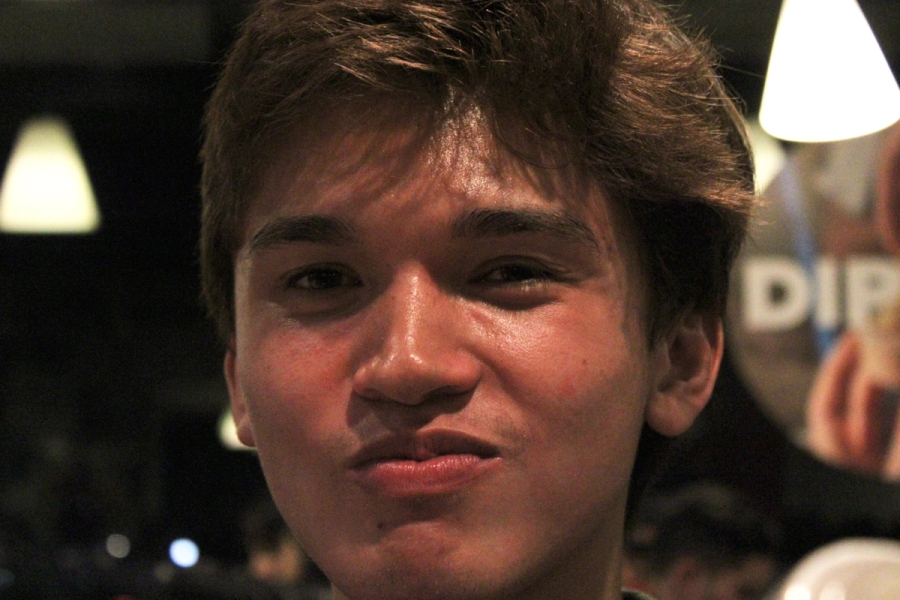 Boy smiling with food in mouth.