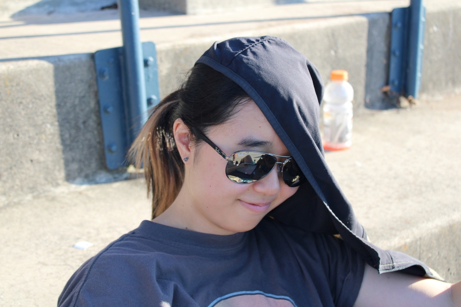 Girl with shades looking down.