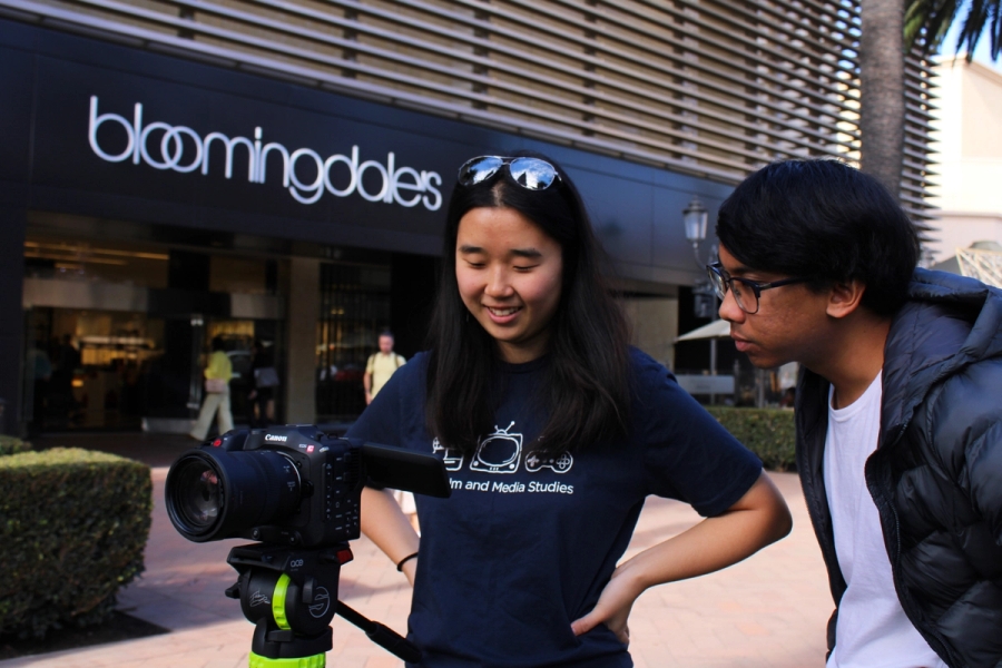 Girl and guy looking at camera recording.