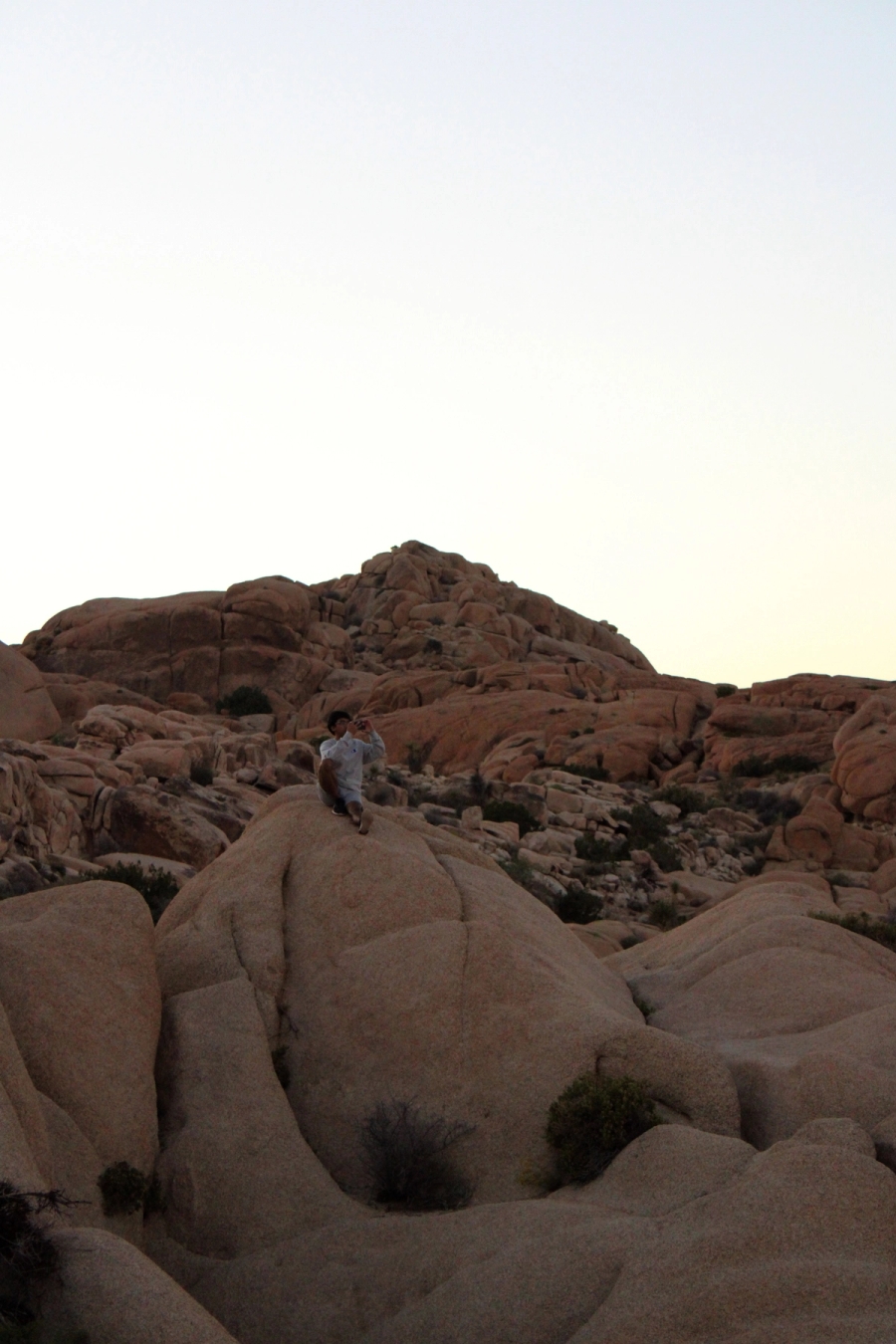 Filipino boy sitting on rocks during sunset.