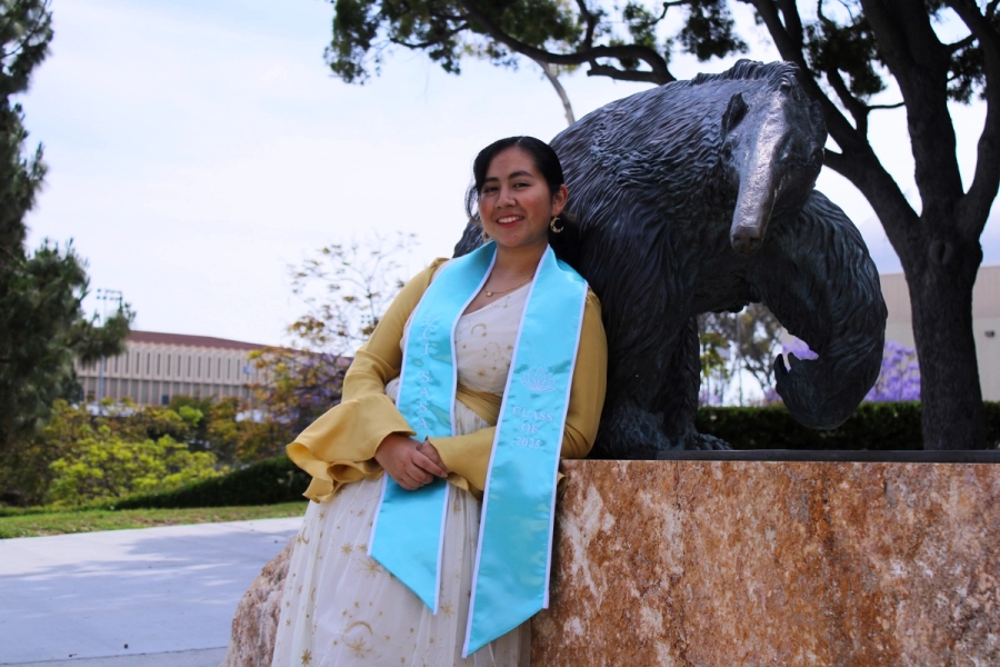Girl standing next to anteater statue.