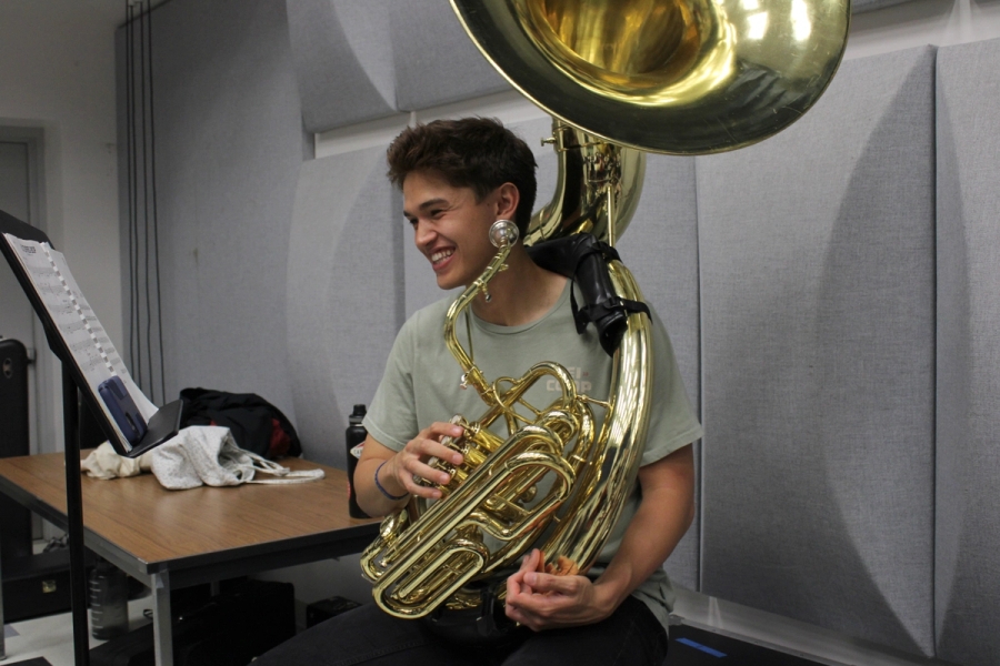 Boy smiling while holding tuba.