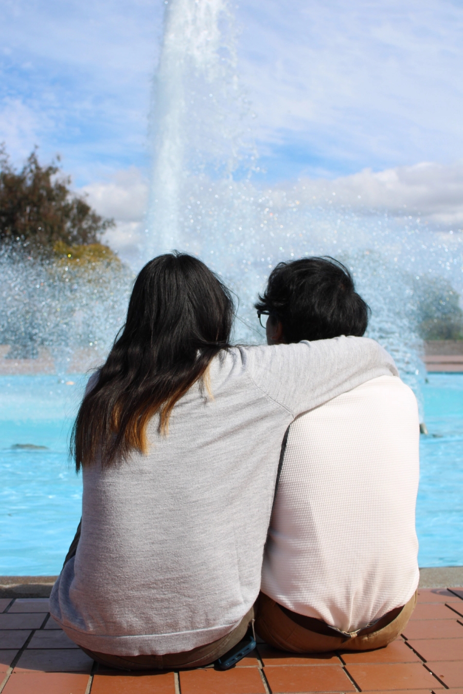 Girl putting arm around boy.