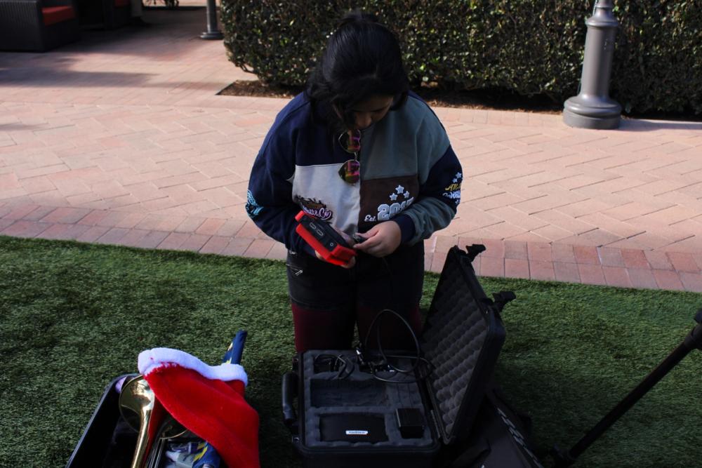 Girl putting battteries in device.