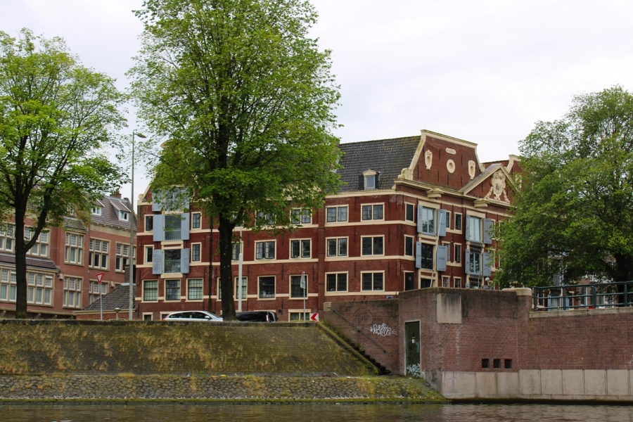 Old residential building on side of river.