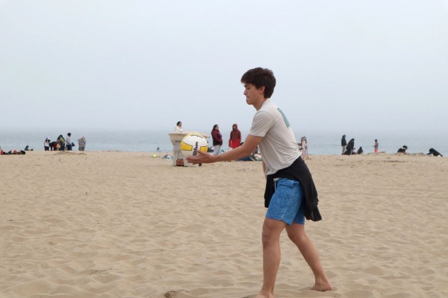 Boy serving the volleyball.