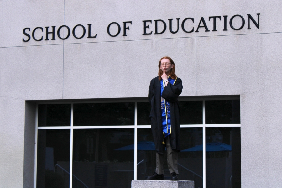 Girl standing near school sign.