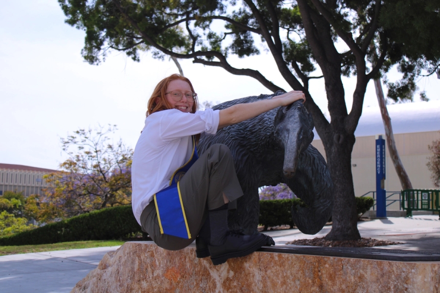Girl hanging from anteater statue.