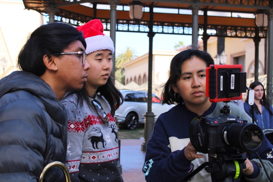 Two girls and a guy looking at monitor.
