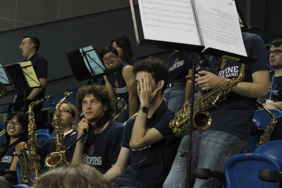 Boy with alto sax trying to hide from the camera.
