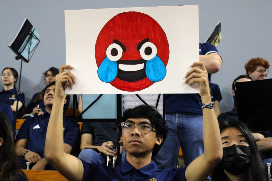 Boy holding red laughing emoji.