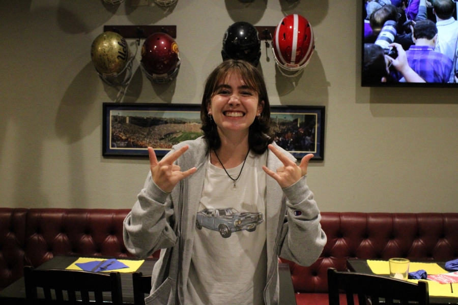 Girl posing with rock and roll signs.