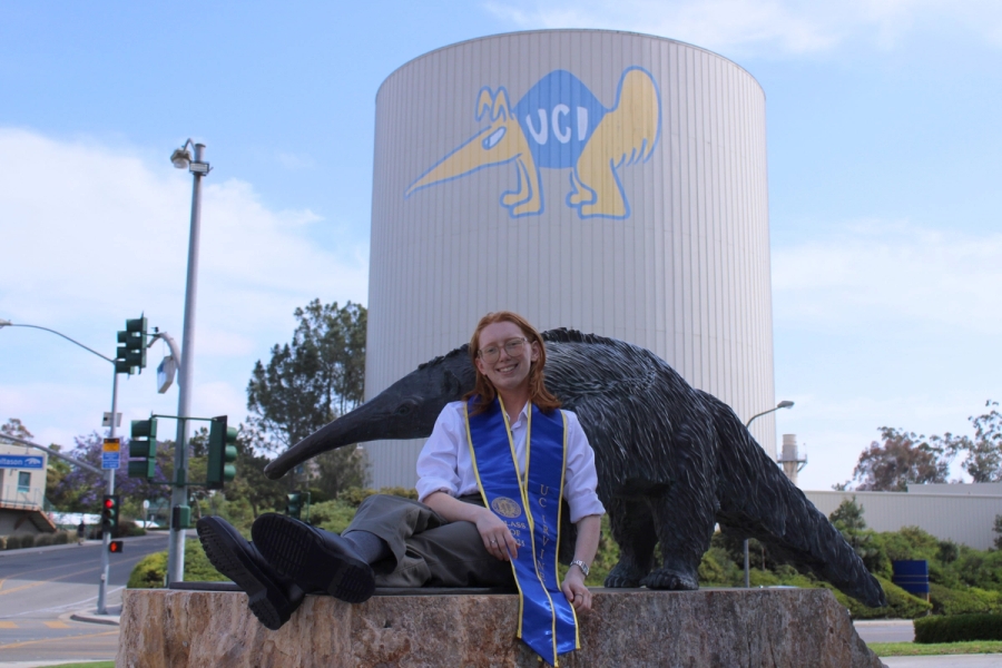 Girl sitting in front of anteater statue.