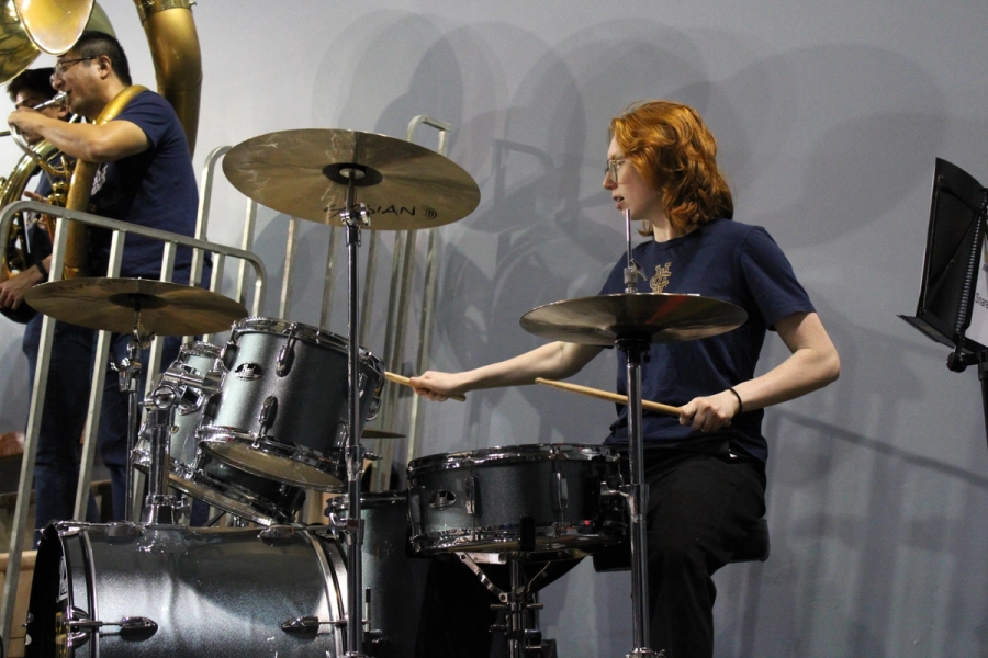 Girl on drumkit playing.