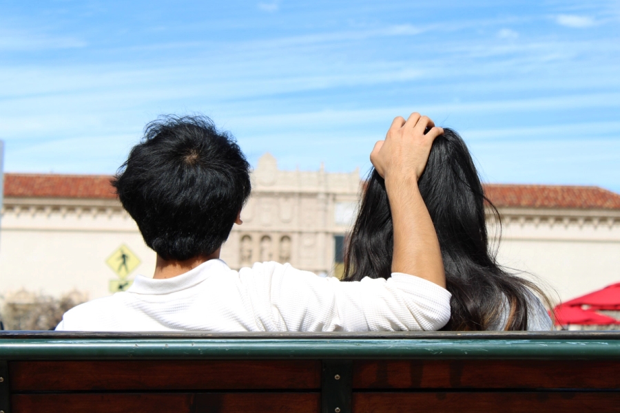 Boy's hand on girl's head.