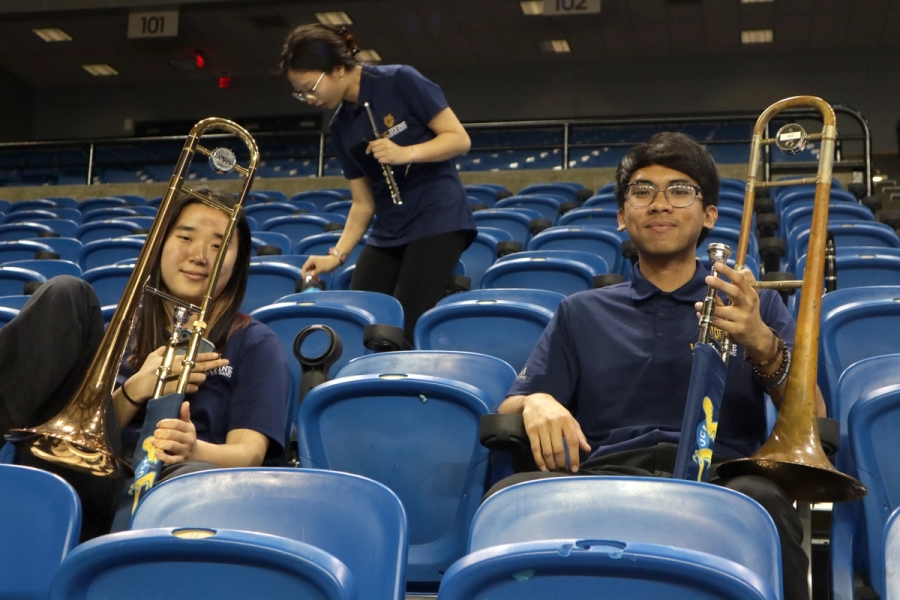 Girl and boy with trombones smiling.