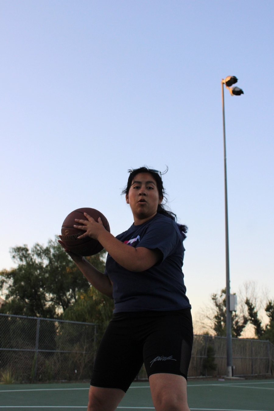 Girl throwing ball towards camera.