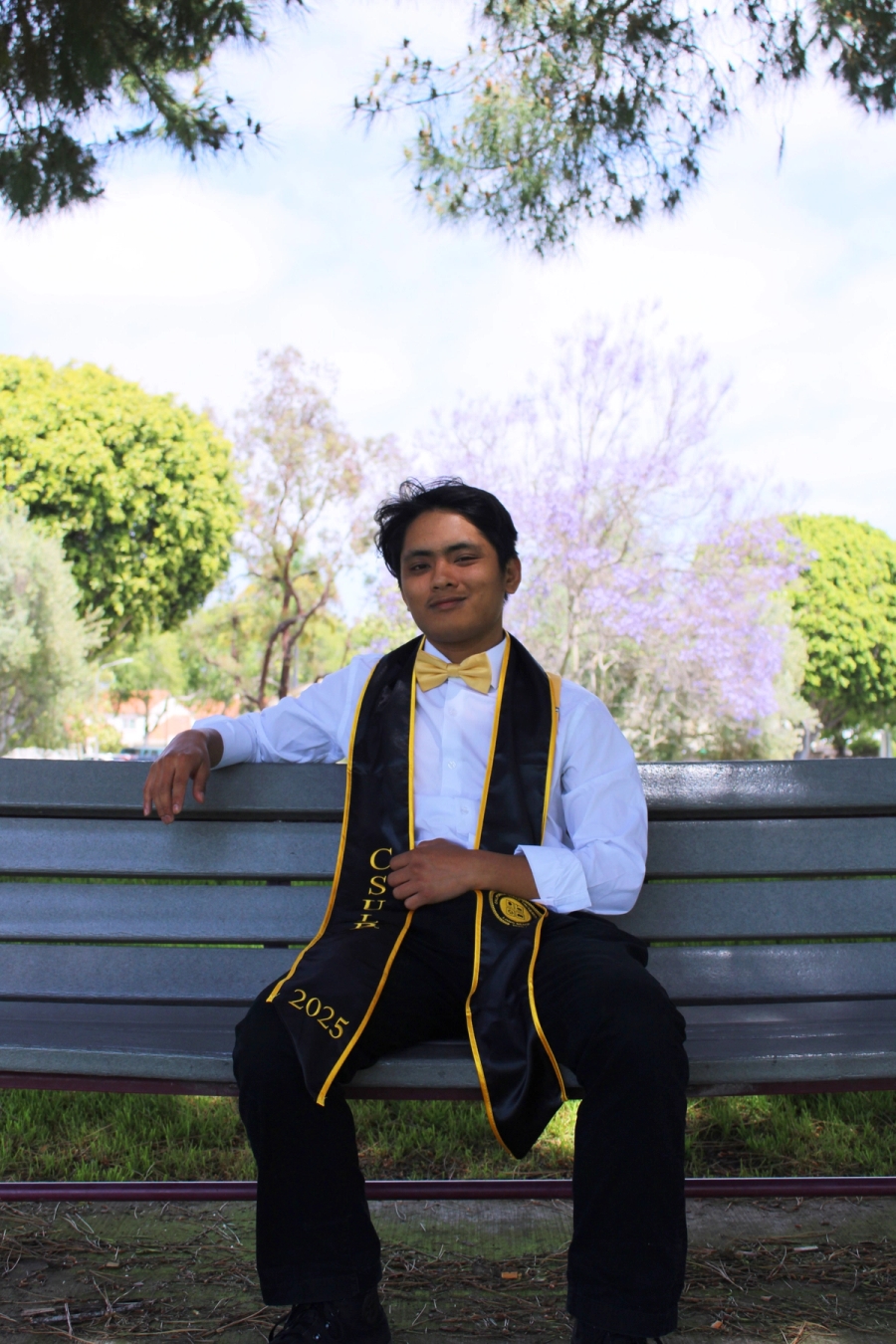 Man in stole sitting on bench.