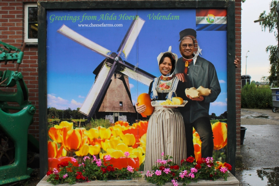 A woman and a man in a postcard cutout.