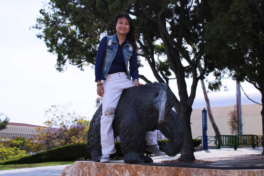 Girl sitting on the anteater statue.