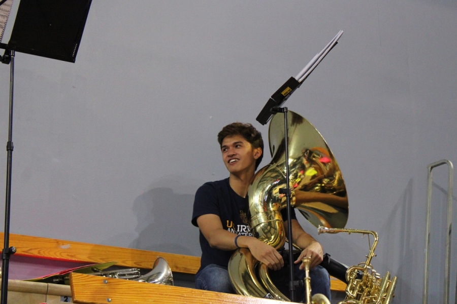 Boy holding a tuba looking to the left.