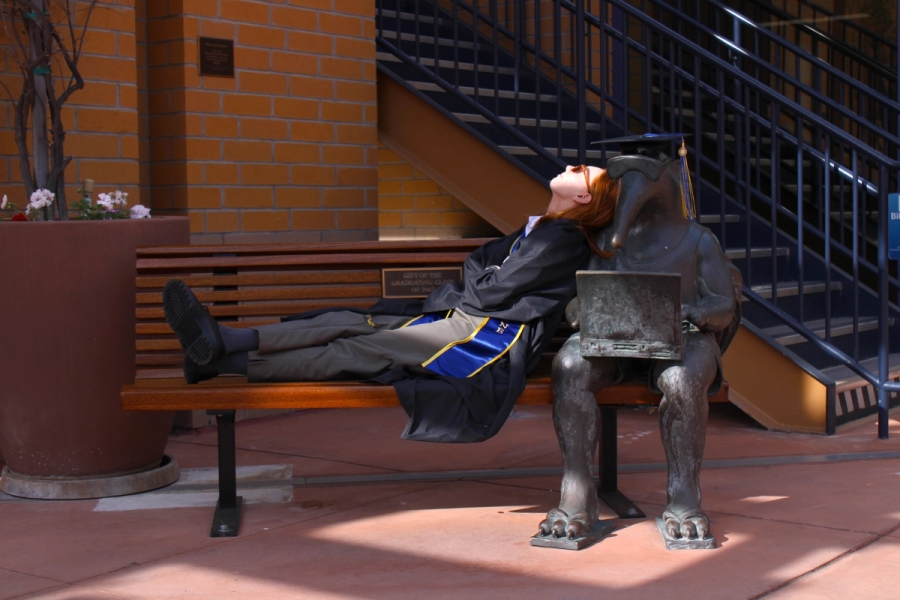 Girl laying on grad anteater statue.