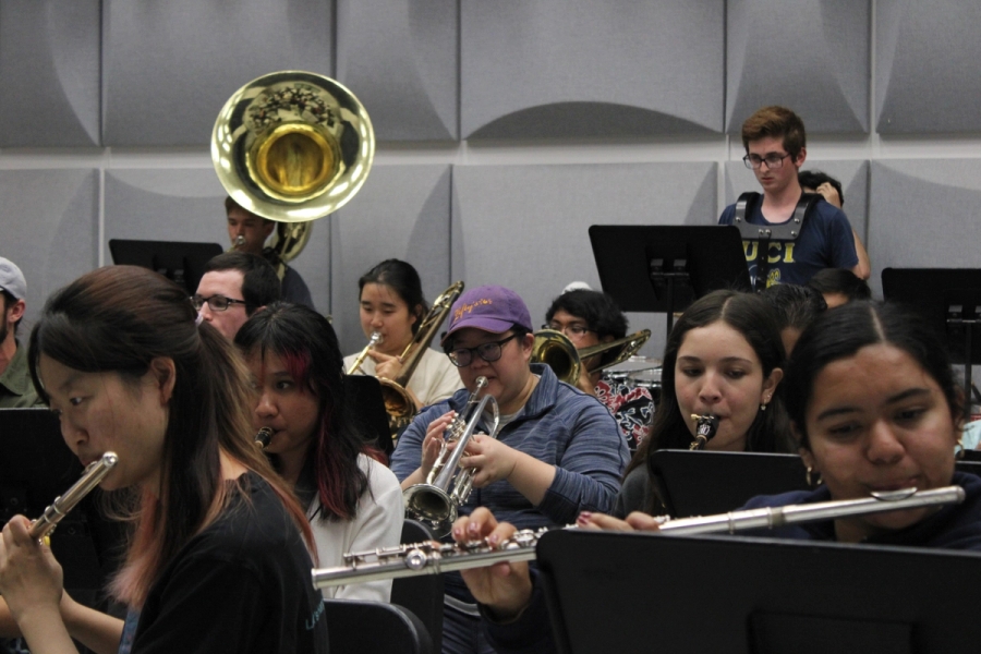 Woman playing trumpet in the middle of the room.