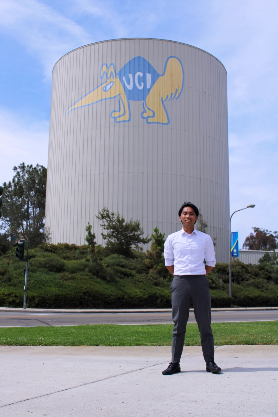 Boy standing in front of water tower.