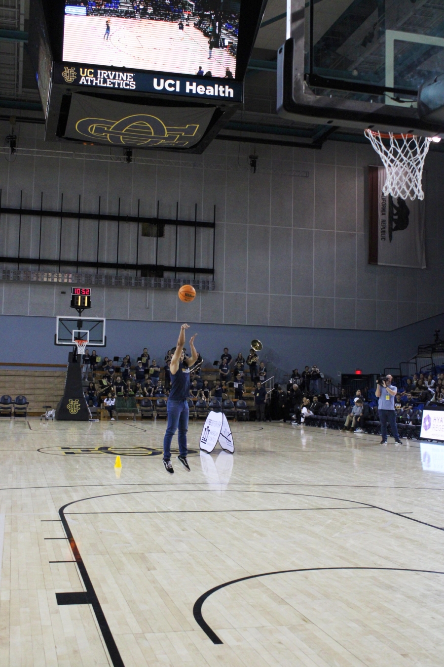 Boy with sleeveless shirt shooting a three.