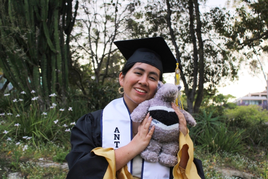 Girl in grad fit holding an anteater plush 1.